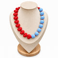 Red heart and powder blue beaded necklace on jewelry display